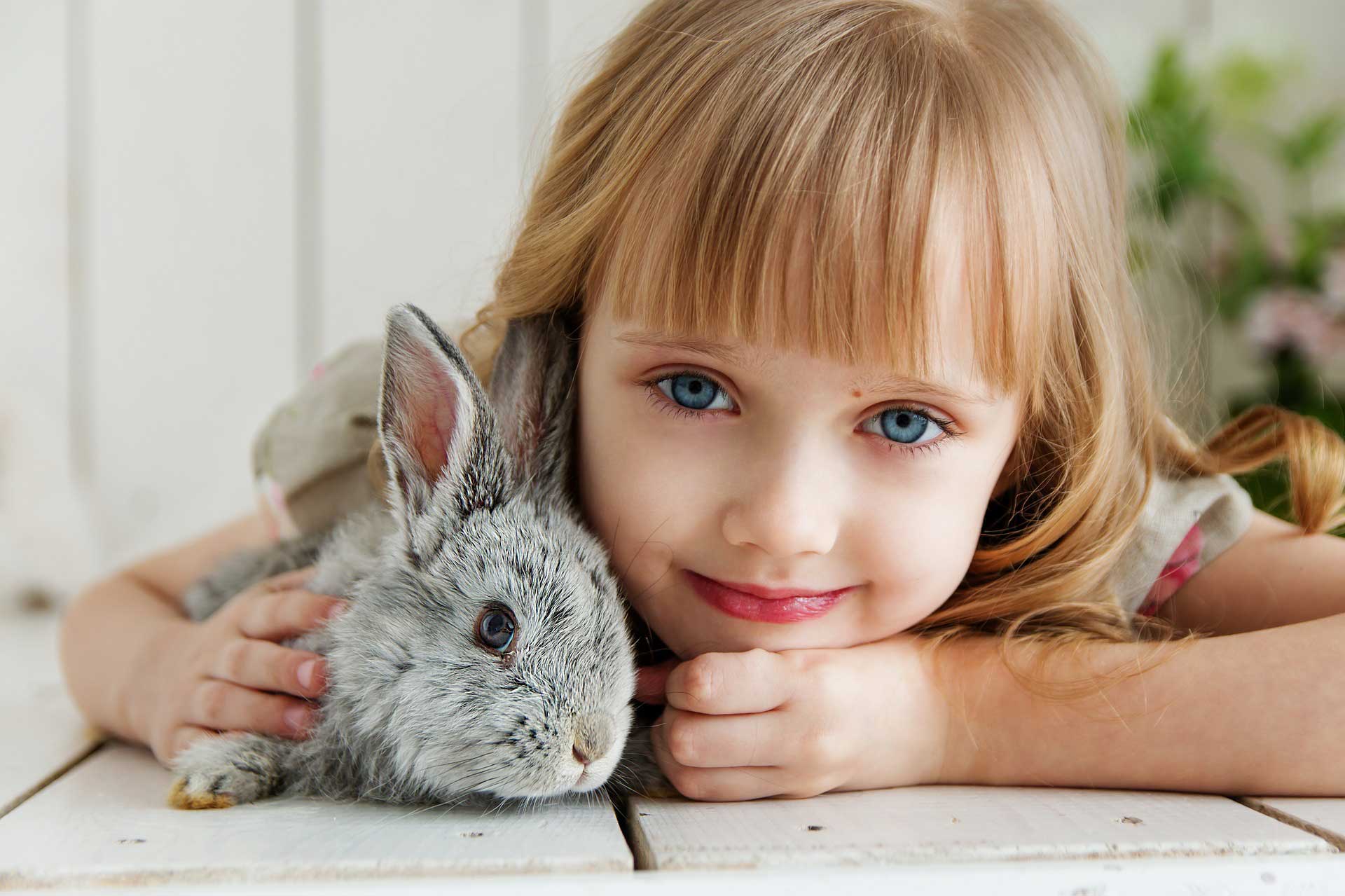 Young girl hugging pet rabbit on deck