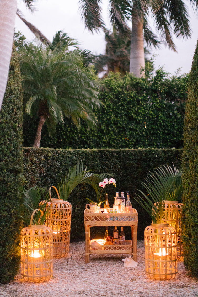 Harbour Island Lantern-Medium shown with other lanterns, illuminated. Natural rattan, open-weave