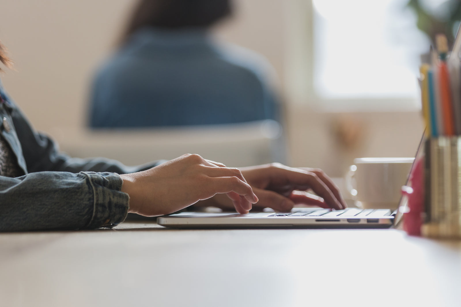 Image of man typing on laptop keyboard at desk