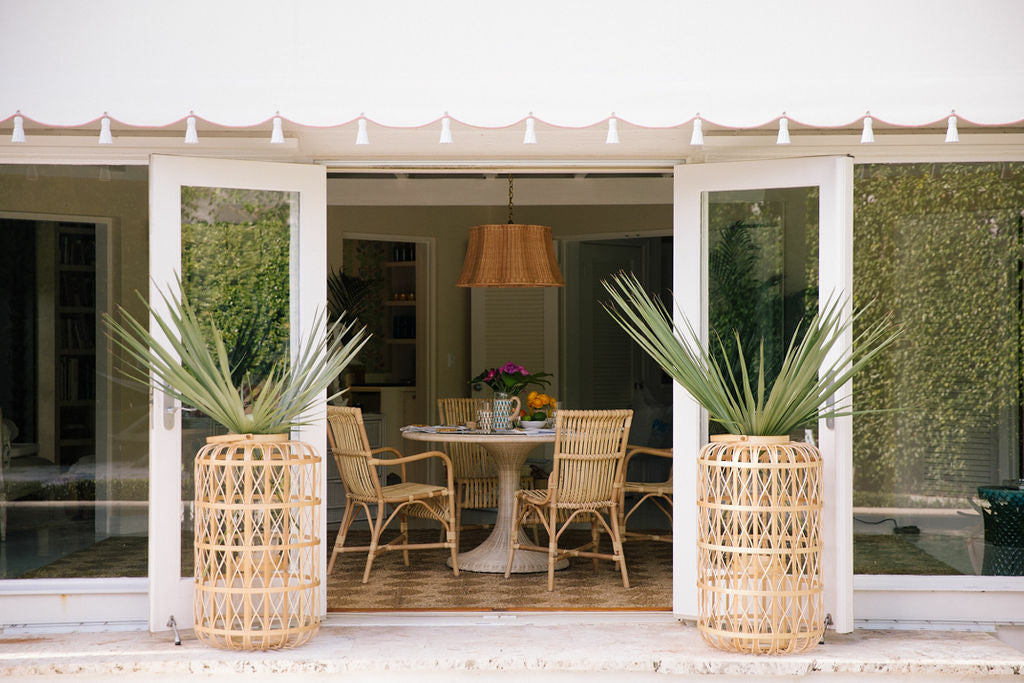 Biscayne Dining Table by Amanda Lindroth rattan table shown in patio setting with Harbour lanterns