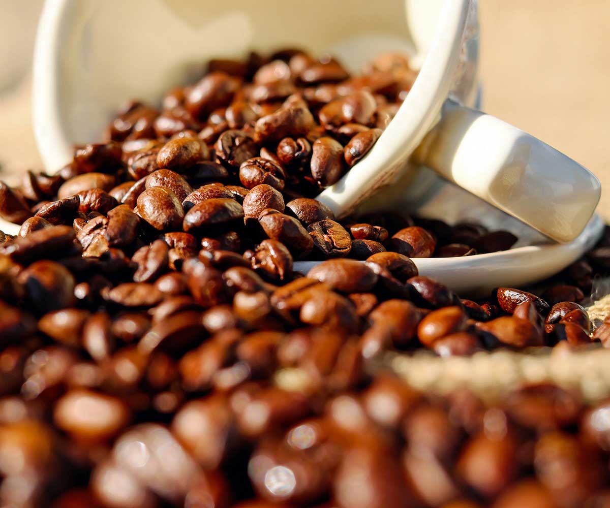 Coffee beans flowing from coffee cup on its side enticing interest in Whiskey Morning Coffee-mobile