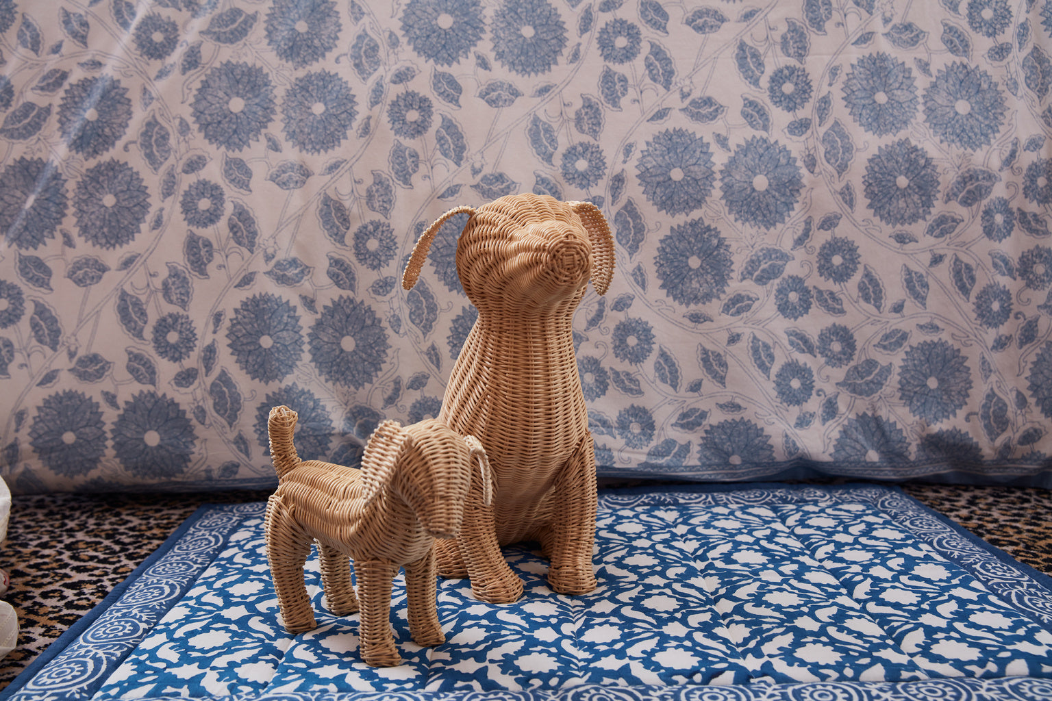 Little Potcake by Amanda Lindroth is a natural rattan weave dog figure. Shown with larger Potcake