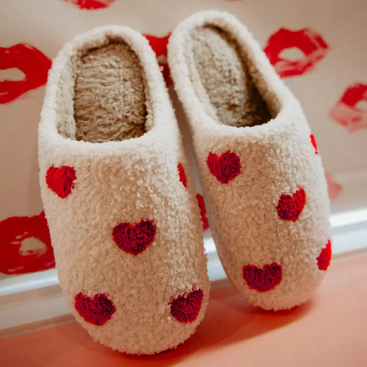 Repeat Red Heart Slippers from Katydid have small red hearts on white Sherpa material with comfy rubber soles.