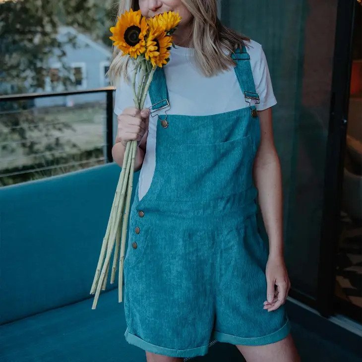Deep Teal Corduroy Overalls worn by model wearing a light blue tee holding sunflowers