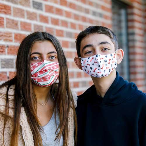 Holiday Paws Kid's Face Mask disposable with paw prints on red ribbon siblings wearing masks