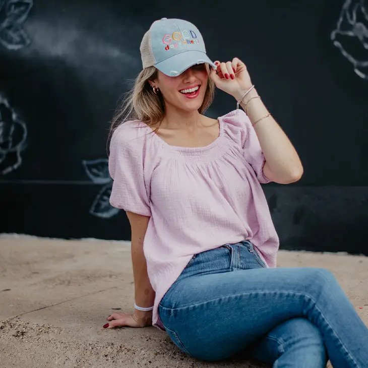 Puff Sleeve Blouse in purple with model wearing new Good Days Ahead trucker hat