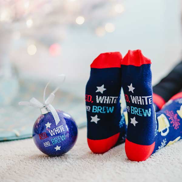 Red, White and Brew Christmas socks and ornament woman wearing socks