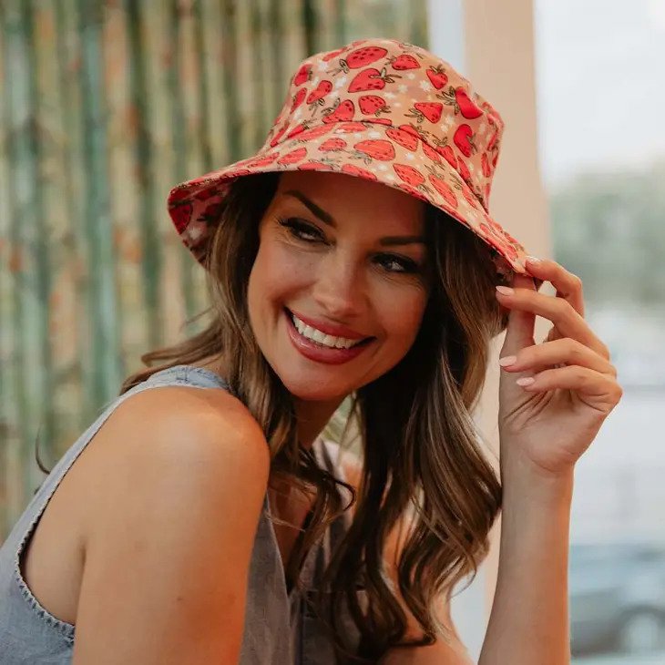 Strawberry Bucket Hat for Women has red strawberries on a field of peach with white stars