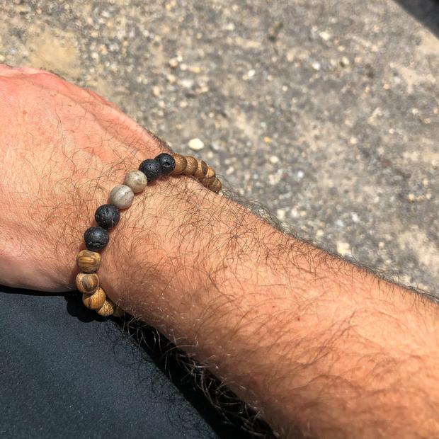Grey feldspar, lava rock and sandalwood beaded bracelet from Everwood man wearing 