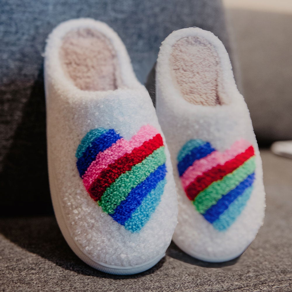 Rainbow Heart Slippers from Katydid. Colorful embroidered rainbow heart shape on white Sherpa material, rubber soles