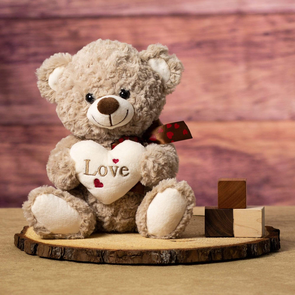 Plush Valentine Bear holding a plush cream-colored heart inscribed with "Love"
